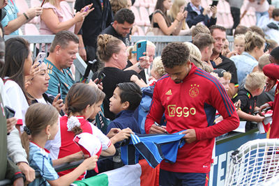 Rensch zet zijn mooiste krabbel op een shirtje. © SV Ajax