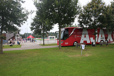 De spelersbus werkt als een magneet op de jeugdige Ajaciedjes. © De Brouwer