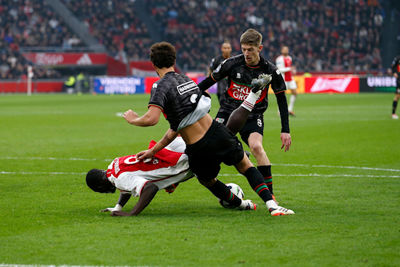 Brobbey wordt tegen het gras gelopen. © De Brouwer