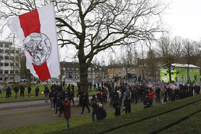 Ajaxsupporters verzamelen zich voor een goed stukje uitzwaaiwerk. © De Brouwer